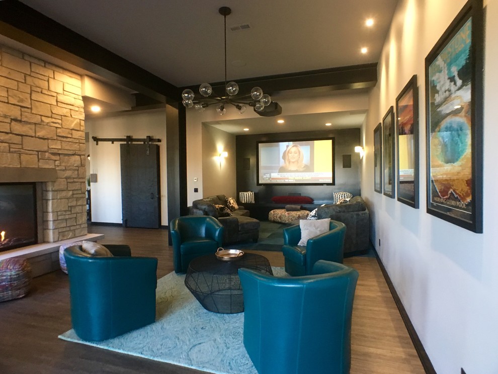 This is an example of a large contemporary open concept home theatre in Milwaukee with a wall-mounted tv, white walls, grey floor and vinyl floors.