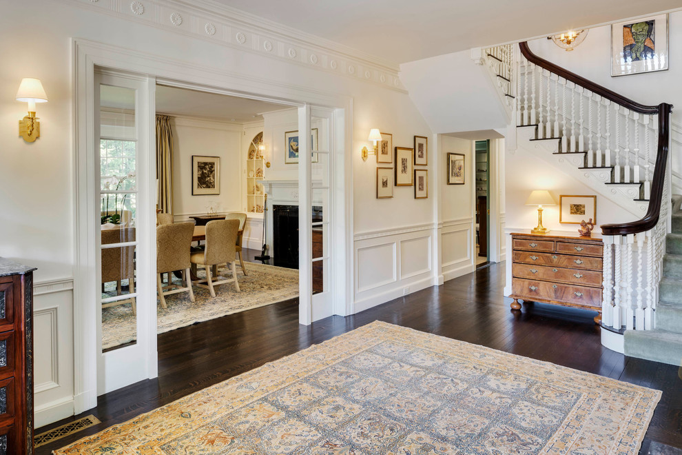 Photo of a mid-sized traditional foyer in Boston with a single front door, white walls, dark hardwood floors, a white front door and brown floor.