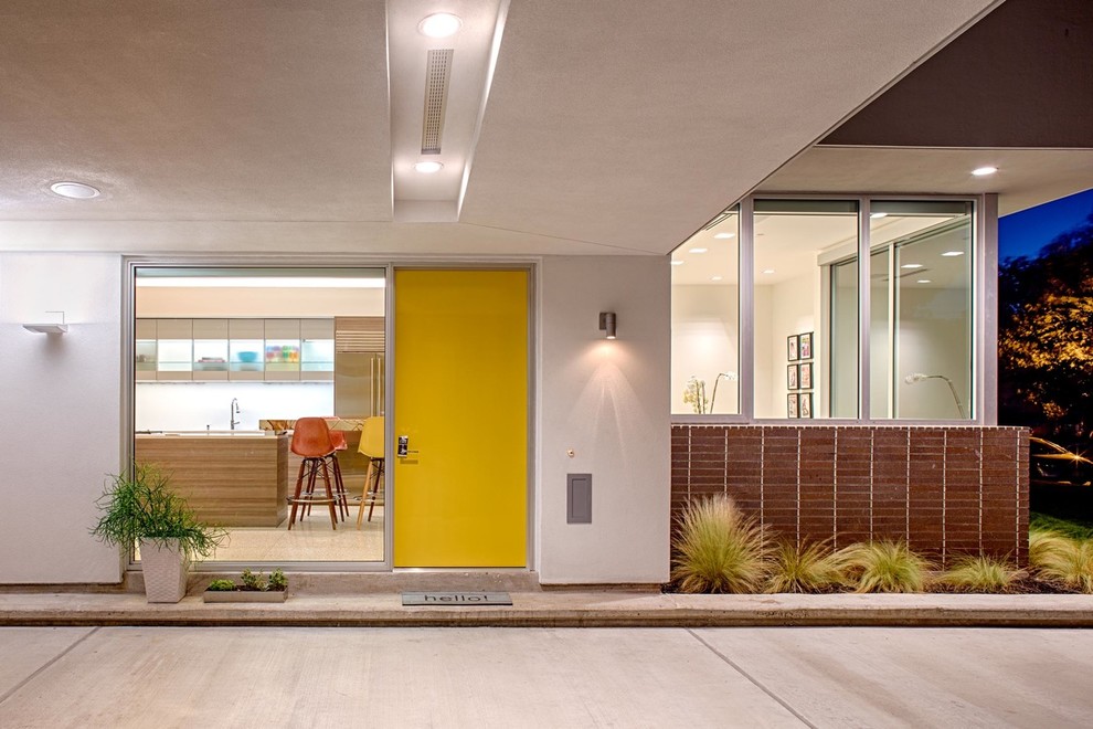 This is an example of a contemporary entryway in Houston with a yellow front door.
