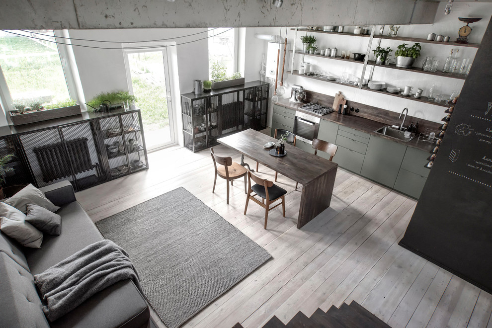 Design ideas for a small industrial single-wall open plan kitchen in Saint Petersburg with flat-panel cabinets, wood benchtops, brown splashback, timber splashback, painted wood floors, brown benchtop, a single-bowl sink, green cabinets, stainless steel appliances and beige floor.