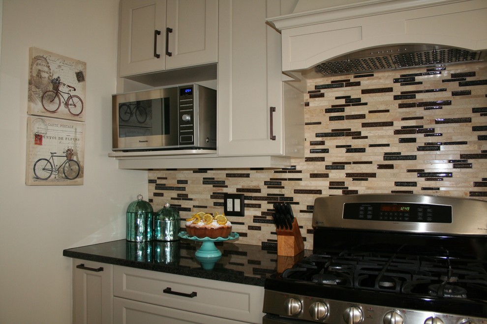 Enclosed kitchen - small transitional l-shaped enclosed kitchen idea in Ottawa with an undermount sink, shaker cabinets, beige cabinets, granite countertops, glass sheet backsplash, stainless steel appliances and no island