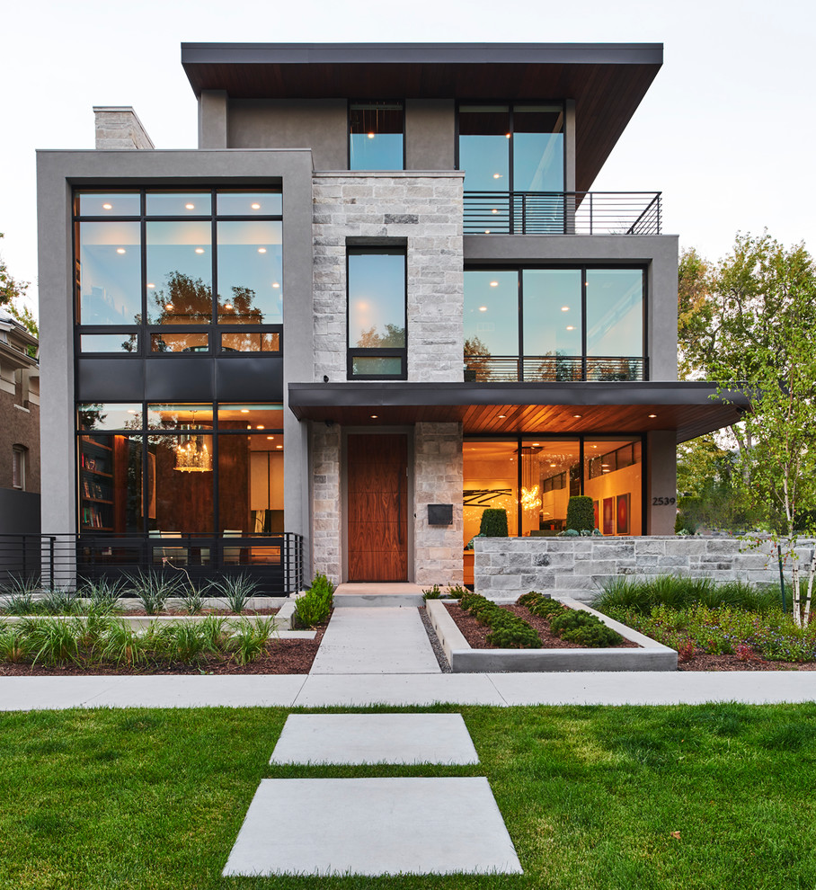 This is an example of a mid-sized contemporary three-storey grey house exterior in Denver with a flat roof and mixed siding.