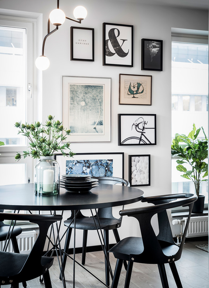 This is an example of a large scandinavian open plan dining in Gothenburg with white walls, light hardwood floors, no fireplace and grey floor.