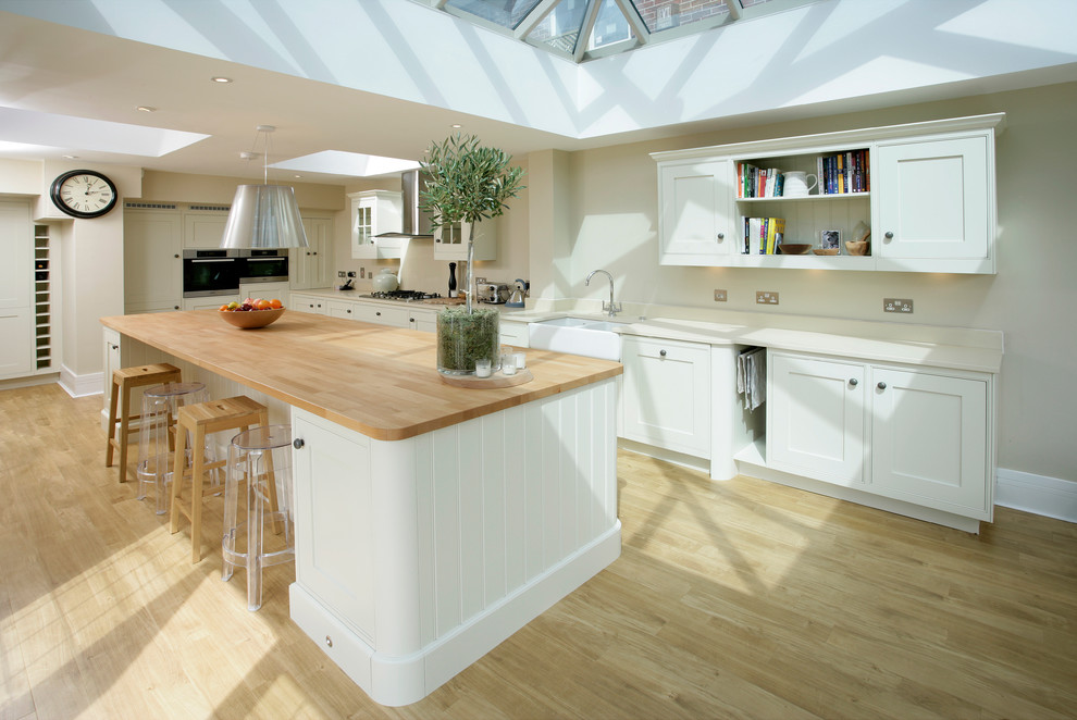 Traditional kitchen in West Midlands with wood benchtops, a farmhouse sink, shaker cabinets and white cabinets.