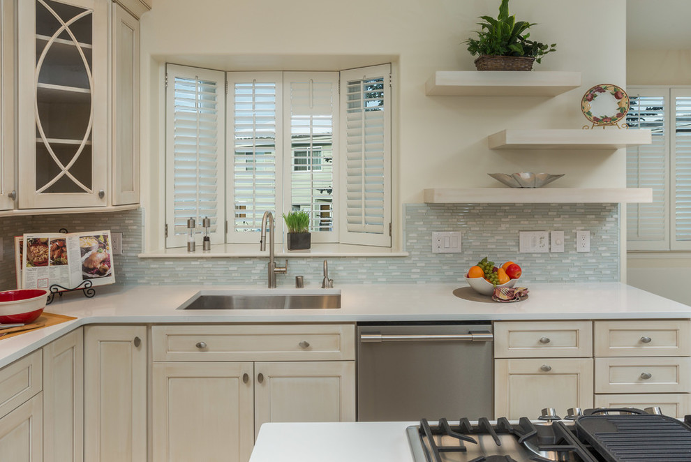 Mid-sized transitional l-shaped eat-in kitchen photo with recessed-panel cabinets, beige cabinets, gray backsplash, stainless steel appliances and an island