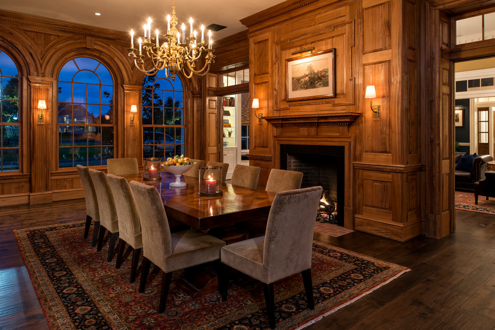 Photo of a large traditional separate dining room in DC Metro with dark hardwood floors, a standard fireplace and a wood fireplace surround.