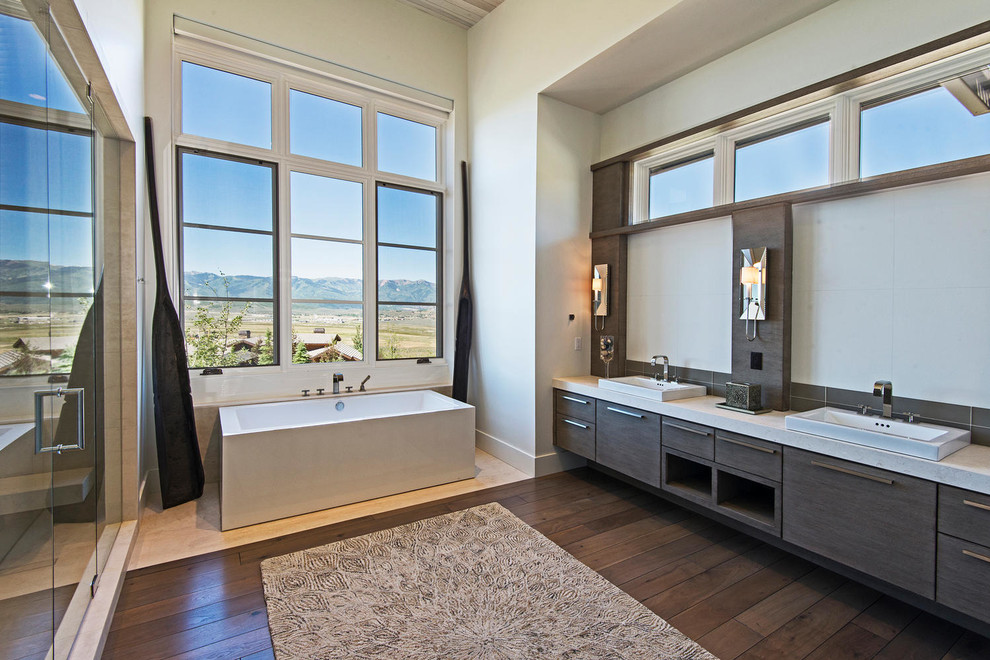 This is an example of a contemporary master bathroom in Salt Lake City with a drop-in sink, flat-panel cabinets, dark wood cabinets, a freestanding tub, an alcove shower, beige walls and dark hardwood floors.
