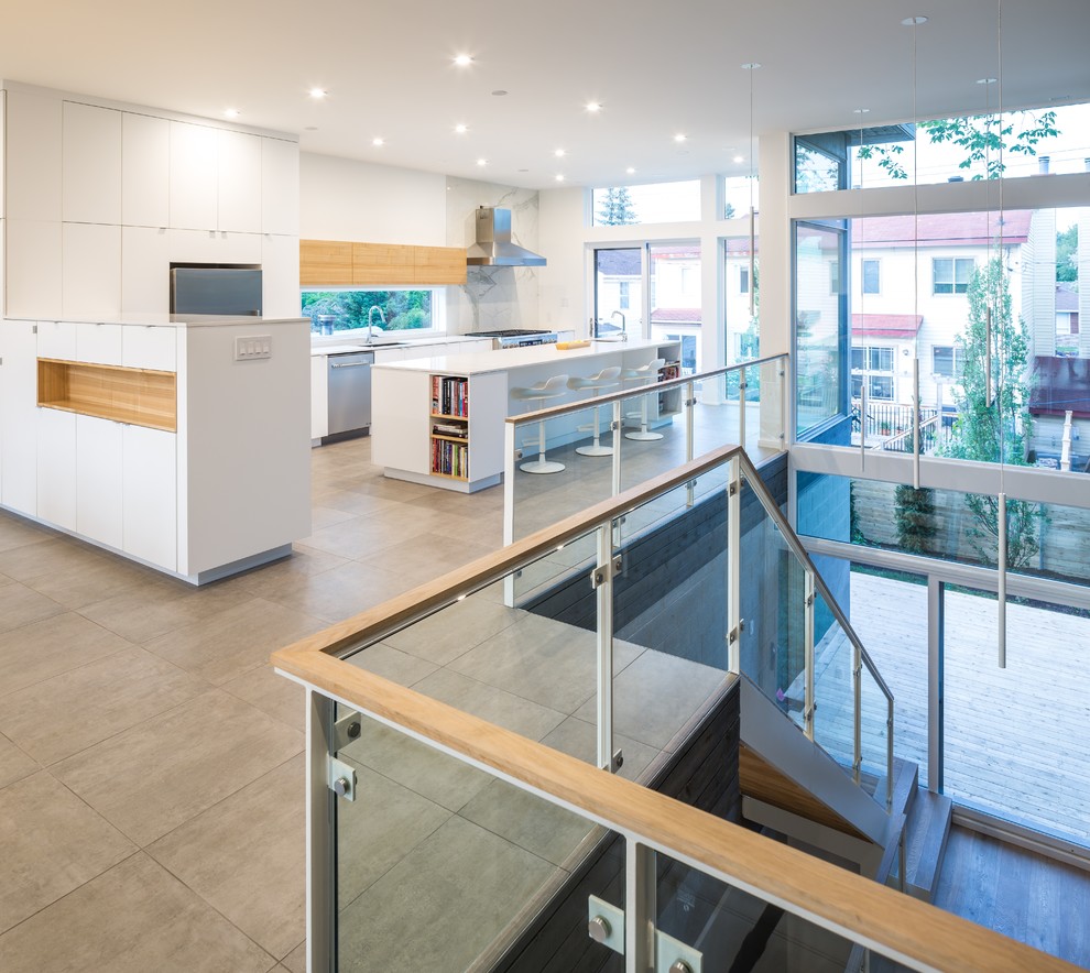 This is an example of a large contemporary l-shaped open plan kitchen in Ottawa with flat-panel cabinets, white cabinets, with island, an undermount sink, solid surface benchtops, white splashback, stainless steel appliances and concrete floors.