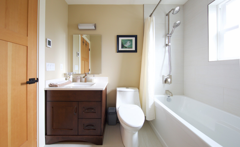 Mid-sized traditional master bathroom in Vancouver with shaker cabinets, medium wood cabinets, a one-piece toilet, white tile, porcelain tile, beige walls, porcelain floors, an undermount sink, engineered quartz benchtops, an alcove tub and a shower/bathtub combo.