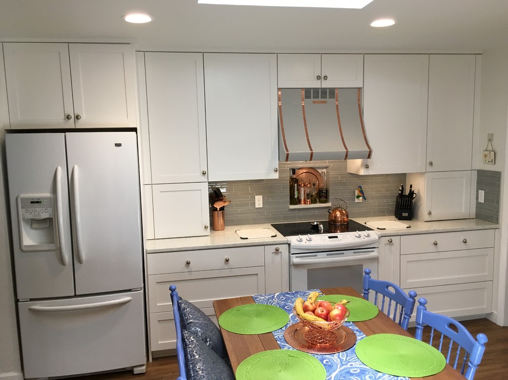 Enclosed kitchen - mid-sized transitional u-shaped vinyl floor enclosed kitchen idea with an undermount sink, shaker cabinets, white cabinets, quartz countertops, gray backsplash, glass tile backsplash, white appliances and no island