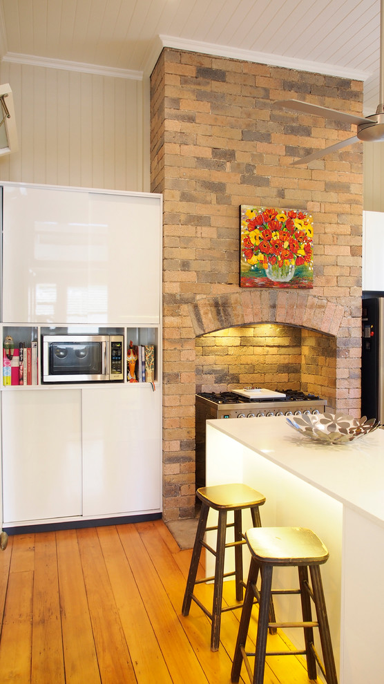This is an example of a contemporary kitchen in Brisbane with flat-panel cabinets and white cabinets.