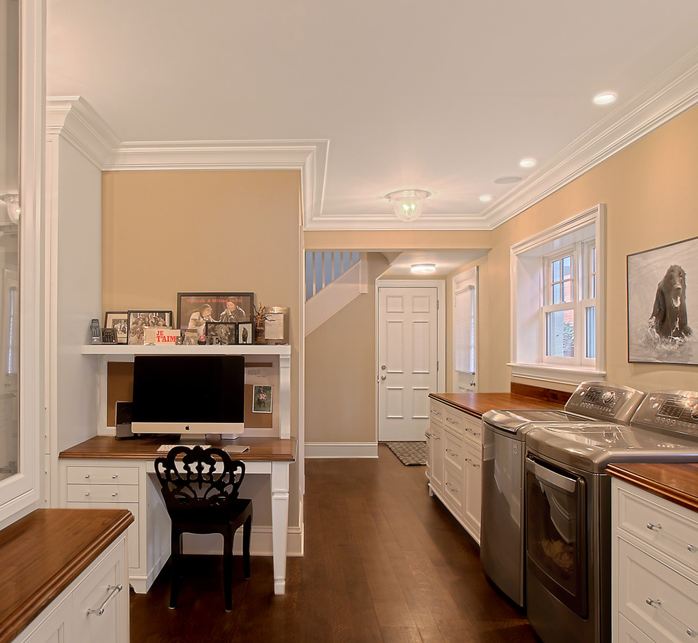 Design ideas for a transitional home office in Chicago with beige walls, dark hardwood floors, a built-in desk and brown floor.