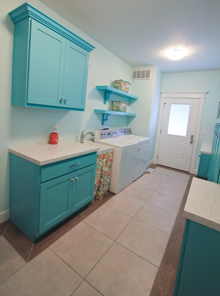 Mid-sized eclectic utility room in Salt Lake City with an utility sink, shaker cabinets, blue cabinets, quartz benchtops, blue walls, porcelain floors and a side-by-side washer and dryer.