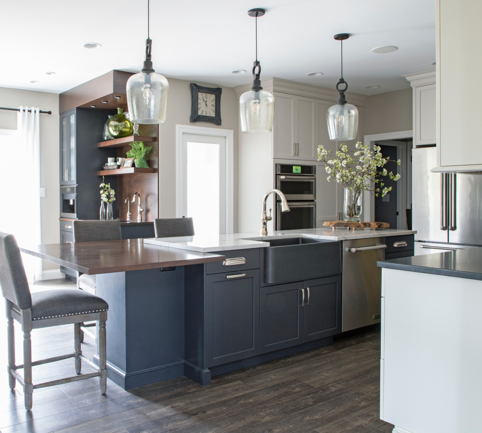 Example of a l-shaped gray floor kitchen design with a farmhouse sink, blue cabinets, quartz countertops, beige backsplash, ceramic backsplash, stainless steel appliances and an island