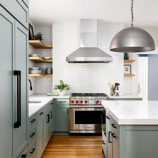 Eat-in kitchen - mid-sized traditional l-shaped medium tone wood floor and brown floor eat-in kitchen idea in DC Metro with a drop-in sink, shaker cabinets, green cabinets, white backsplash, subway tile backsplash, stainless steel appliances, an island and white countertops