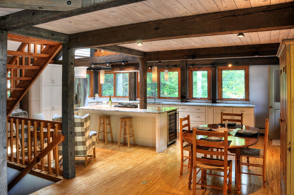 Inspiration for a large transitional l-shaped light wood floor and beige floor eat-in kitchen remodel in Boston with an undermount sink, shaker cabinets, white cabinets, stainless steel appliances, an island and quartzite countertops