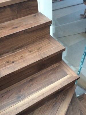 Example of a transitional wooden staircase design in Calgary with wooden risers