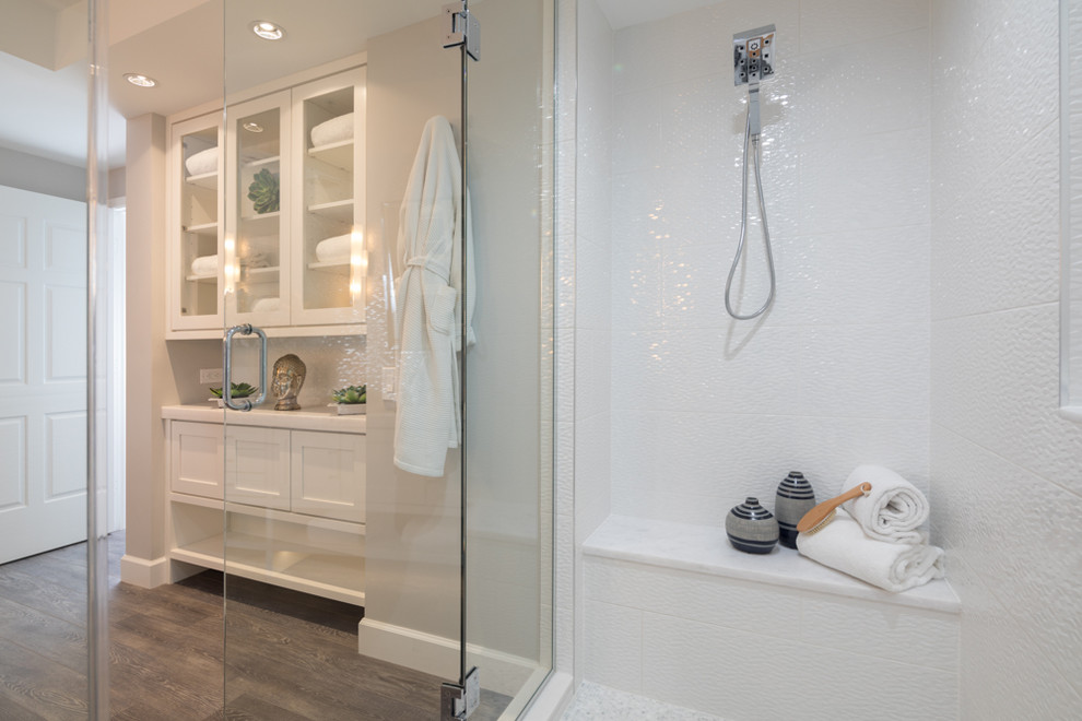 Photo of a mid-sized contemporary master bathroom in Miami with shaker cabinets, white cabinets, an open shower, white tile, ceramic tile, grey walls, laminate floors, engineered quartz benchtops, grey floor and an open shower.