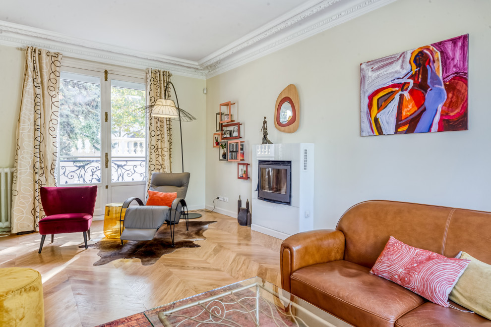 Mid-sized eclectic living room in Paris with beige walls, light hardwood floors, a standard fireplace, no tv and recessed.