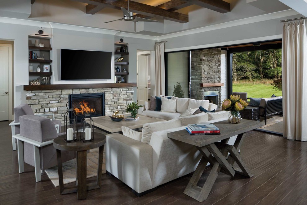 Inspiration for a transitional open concept family room in Other with grey walls, dark hardwood floors, a standard fireplace, a stone fireplace surround, a wall-mounted tv and brown floor.