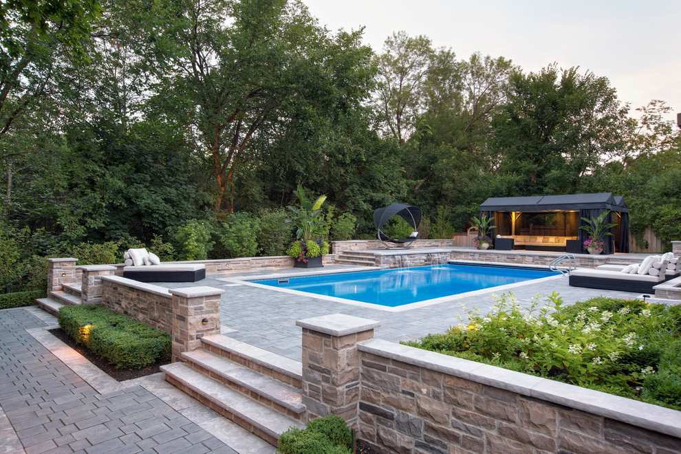 Photo of a large contemporary backyard rectangular lap pool in Toronto with concrete pavers.