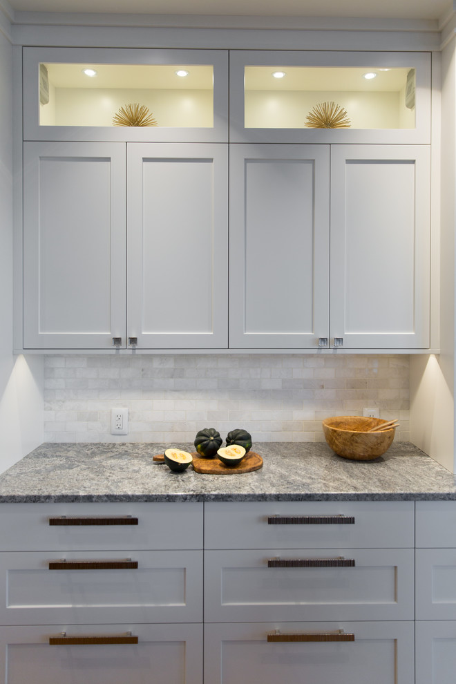 Inspiration for a mid-sized transitional l-shaped medium tone wood floor eat-in kitchen remodel in Vancouver with an undermount sink, shaker cabinets, white cabinets, granite countertops, white backsplash, white appliances and an island