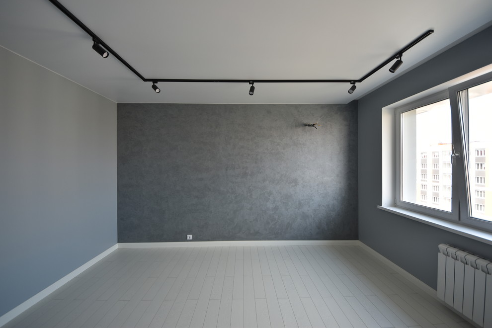 Aménagement d'un salon industriel de taille moyenne et fermé avec une salle de réception, un mur bleu, sol en stratifié, un téléviseur fixé au mur et un sol blanc.