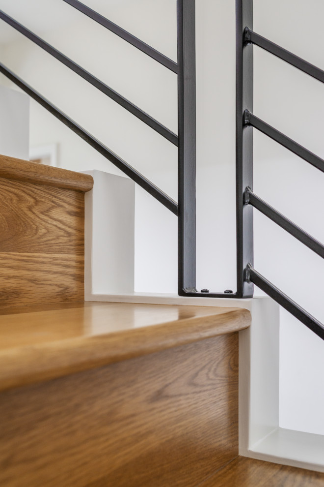 This is an example of a mid-sized contemporary wood straight staircase in Seattle with wood risers and metal railing.