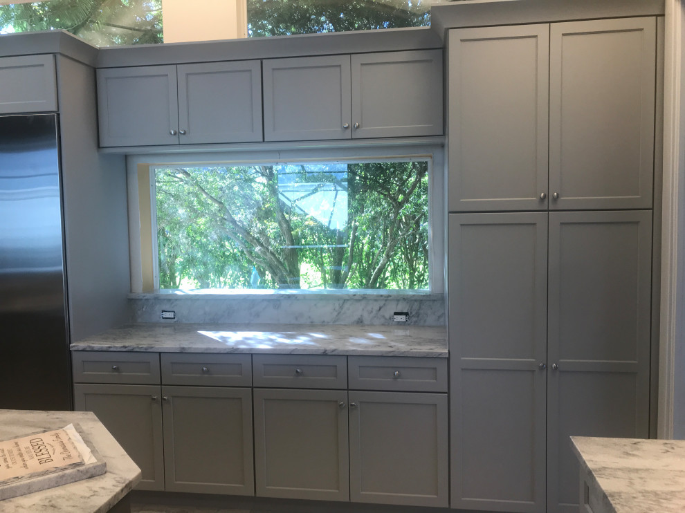 Eat-in kitchen - large transitional porcelain tile and gray floor eat-in kitchen idea in Miami with a triple-bowl sink, flat-panel cabinets, gray cabinets, marble countertops, gray backsplash, slate backsplash, stainless steel appliances, two islands and gray countertops