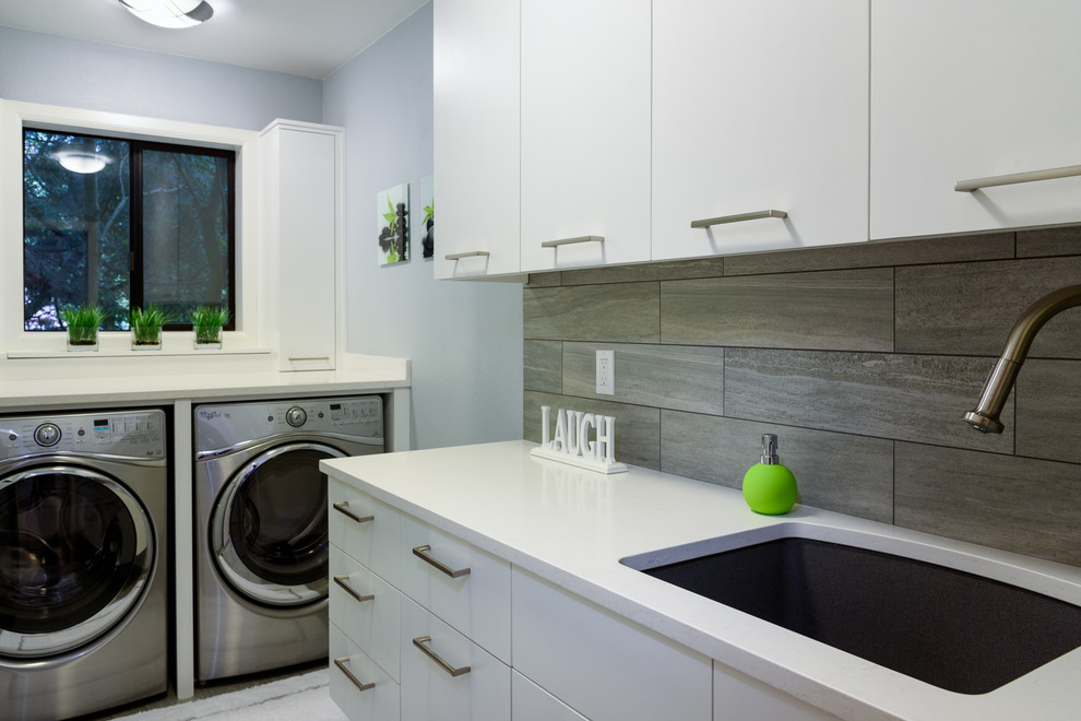 Design ideas for a mid-sized modern single-wall utility room in Seattle with an undermount sink, flat-panel cabinets, white cabinets, quartz benchtops, grey walls and a side-by-side washer and dryer.