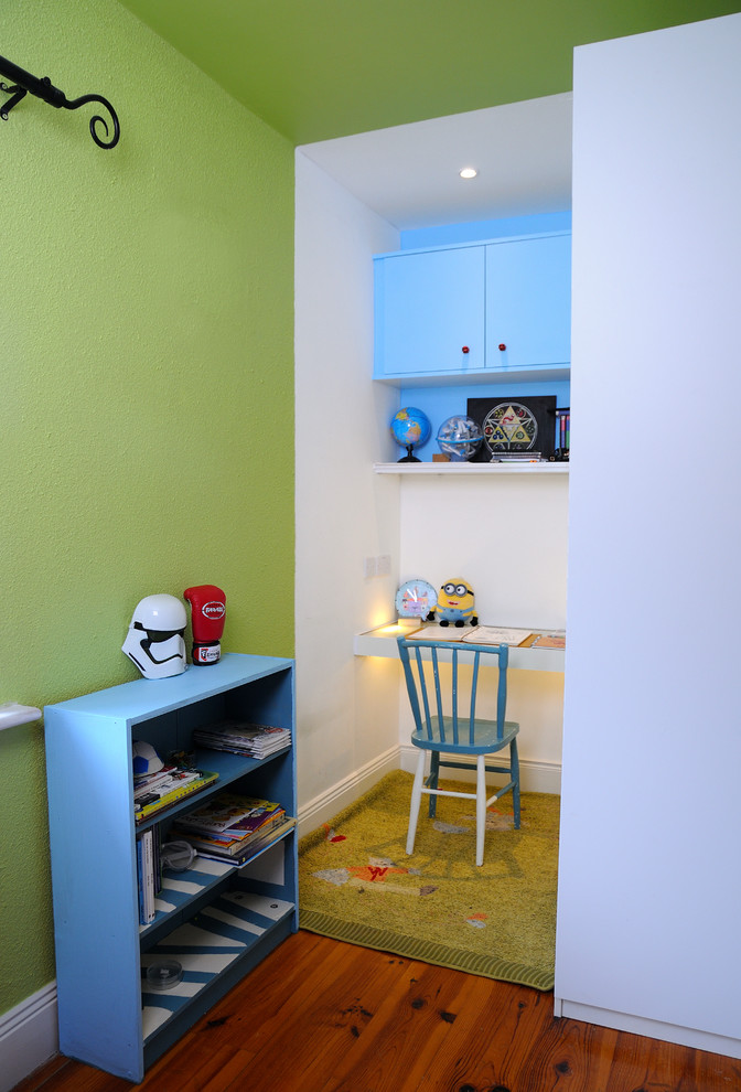 This is an example of a small contemporary kids' room for kids 4-10 years old and boys in Other with green walls.