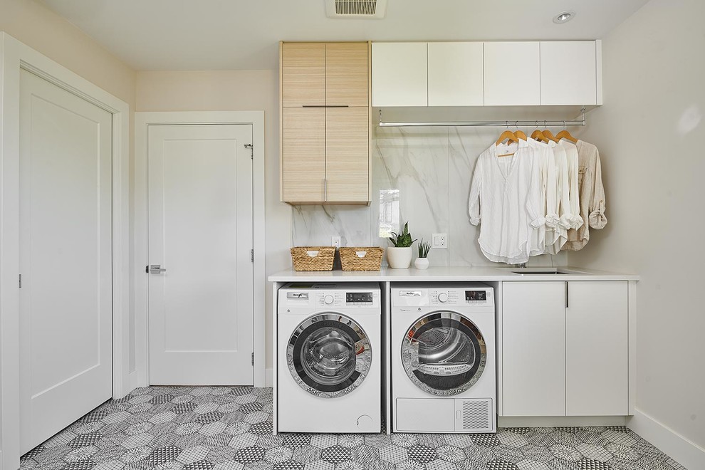 Inspiration for a mid-sized scandinavian single-wall dedicated laundry room in Vancouver with an undermount sink, flat-panel cabinets, white cabinets, quartz benchtops, ceramic floors, a side-by-side washer and dryer, white benchtop, white walls and multi-coloured floor.