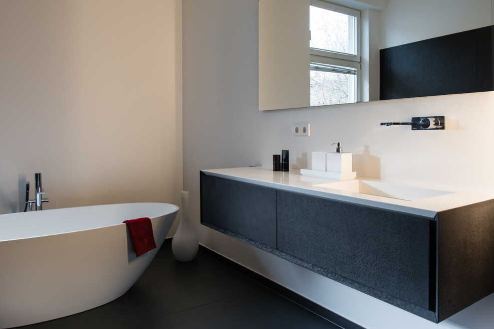 Duschbad With flächenbündigen Schrankfronten, grauen Schränken, freistehender Badewanne, bodengleicher Dusche, Toilette mit Aufsatzspülkasten, weißen Fliesen, Keramikfliesen, weißer Wandfarbe, braunem Holzboden, Aufsatzwaschbecken, gefliestem Waschtisch, beigem Boden and Duschvorhang-Duschabtrennung in Stuttgart