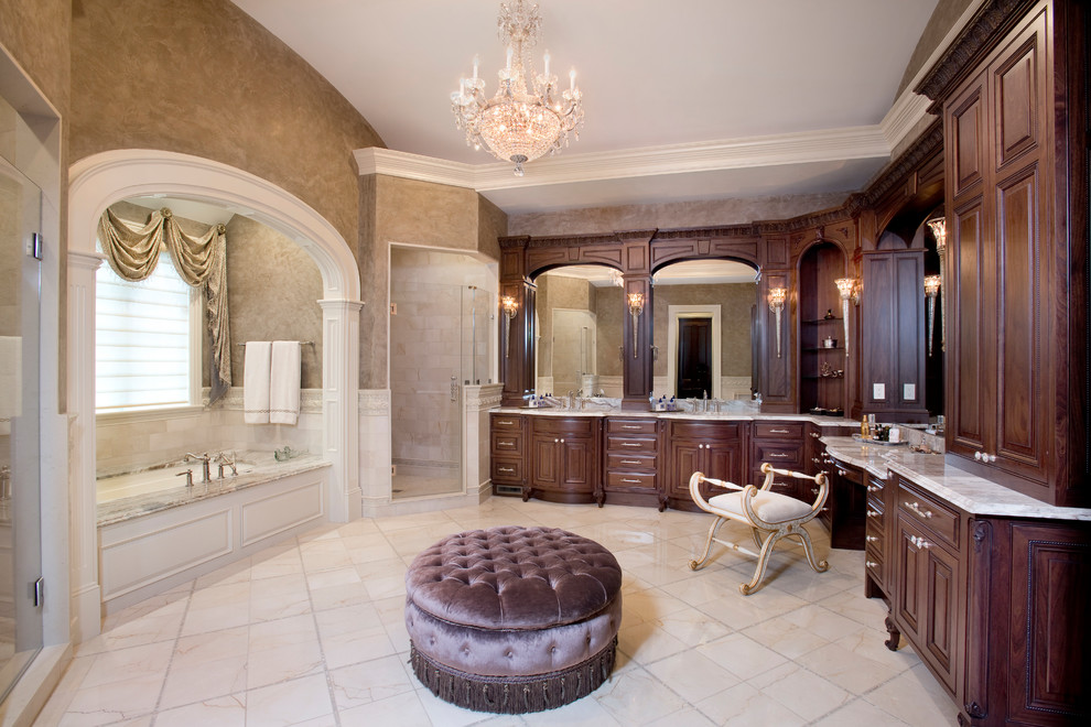 This is an example of a traditional master bathroom in Boston with raised-panel cabinets, dark wood cabinets, an undermount tub, a corner shower, beige floor and a hinged shower door.