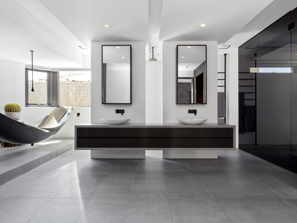 Photo of a contemporary master bathroom in Perth with flat-panel cabinets, black cabinets, a freestanding tub, white walls, a vessel sink, grey floor and grey benchtops.
