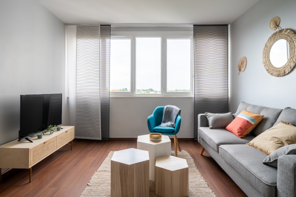Mittelgroßes, Offenes Modernes Wohnzimmer in grau-weiß ohne Kamin mit blauer Wandfarbe, dunklem Holzboden, freistehendem TV und braunem Boden in Nantes