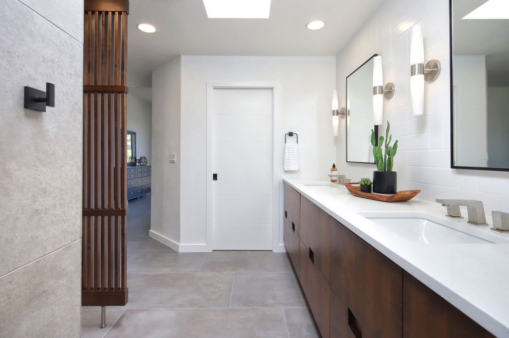 Photo of a mid-sized midcentury master bathroom in Phoenix with flat-panel cabinets, medium wood cabinets, a curbless shower, a one-piece toilet, gray tile, porcelain tile, white walls, porcelain floors, an undermount sink, engineered quartz benchtops, grey floor, an open shower, white benchtops, a niche, a double vanity, a built-in vanity and wood walls.