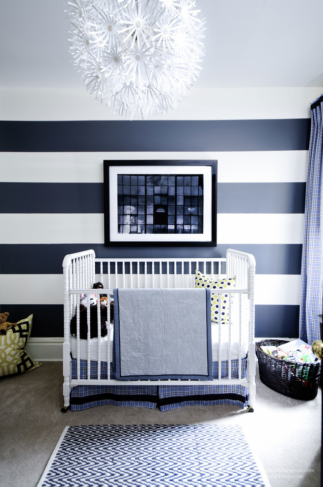 Photo of a small transitional nursery for boys in Toronto with blue walls and carpet.