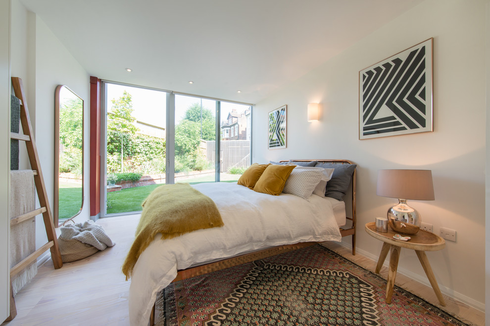 Photo of a contemporary bedroom in London with white walls and beige floor.