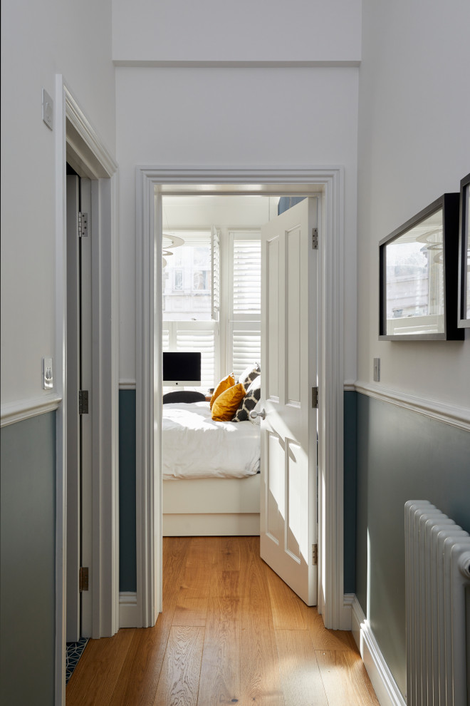 Inspiration pour un petit couloir minimaliste avec un mur gris, parquet clair, un sol marron et du lambris de bois.