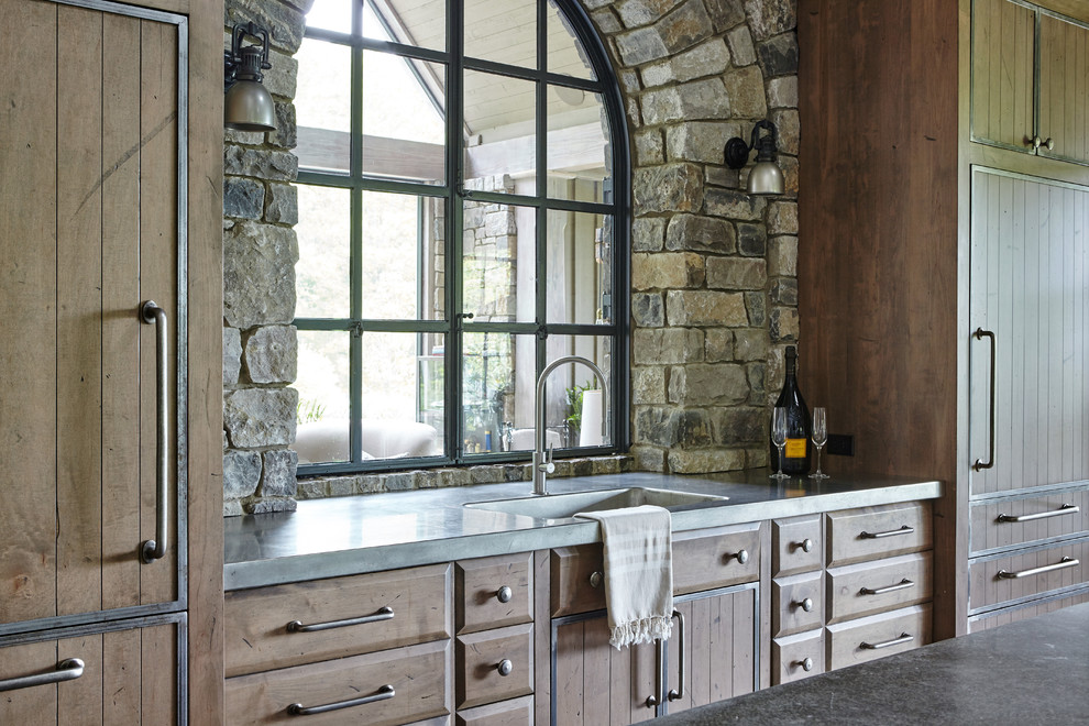 Inspiration for a country open plan kitchen in Nashville with an undermount sink, flat-panel cabinets, medium wood cabinets, grey splashback, panelled appliances, limestone floors and beige floor.