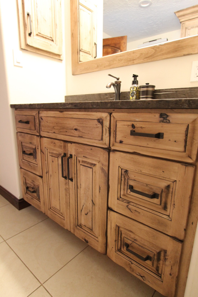Bathroom - large rustic master double-sink bathroom idea with furniture-like cabinets, distressed cabinets, an undermount sink, granite countertops, multicolored countertops and a built-in vanity