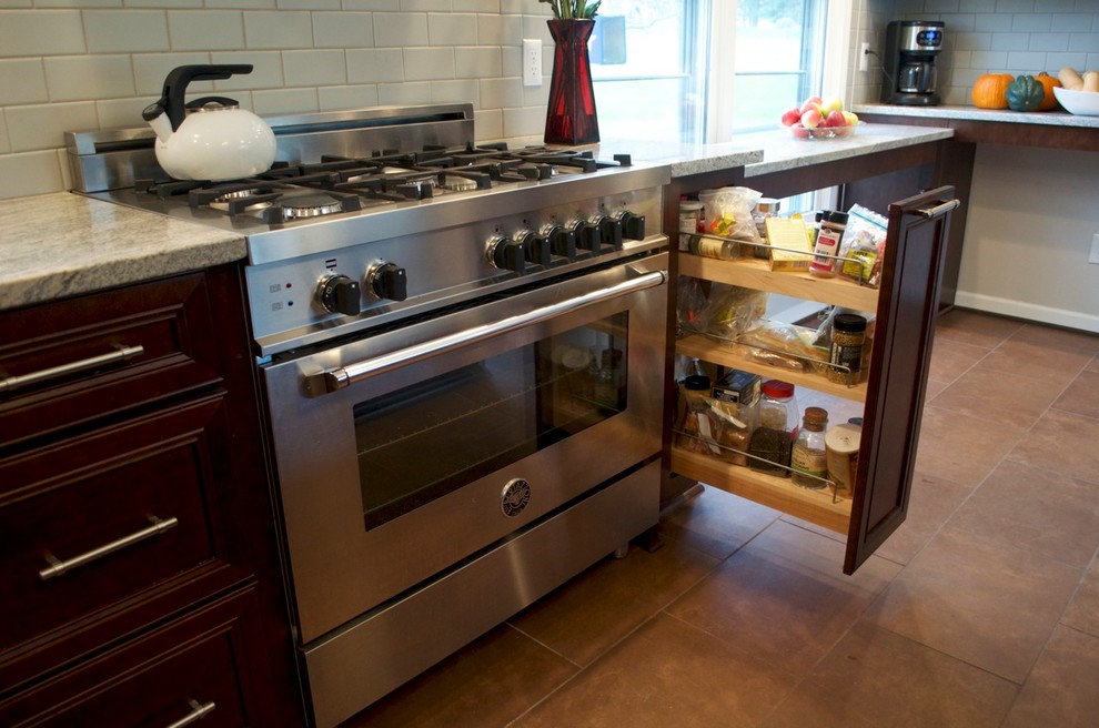 Transitional ceramic tile eat-in kitchen photo in New York with recessed-panel cabinets, dark wood cabinets, granite countertops, ceramic backsplash and stainless steel appliances