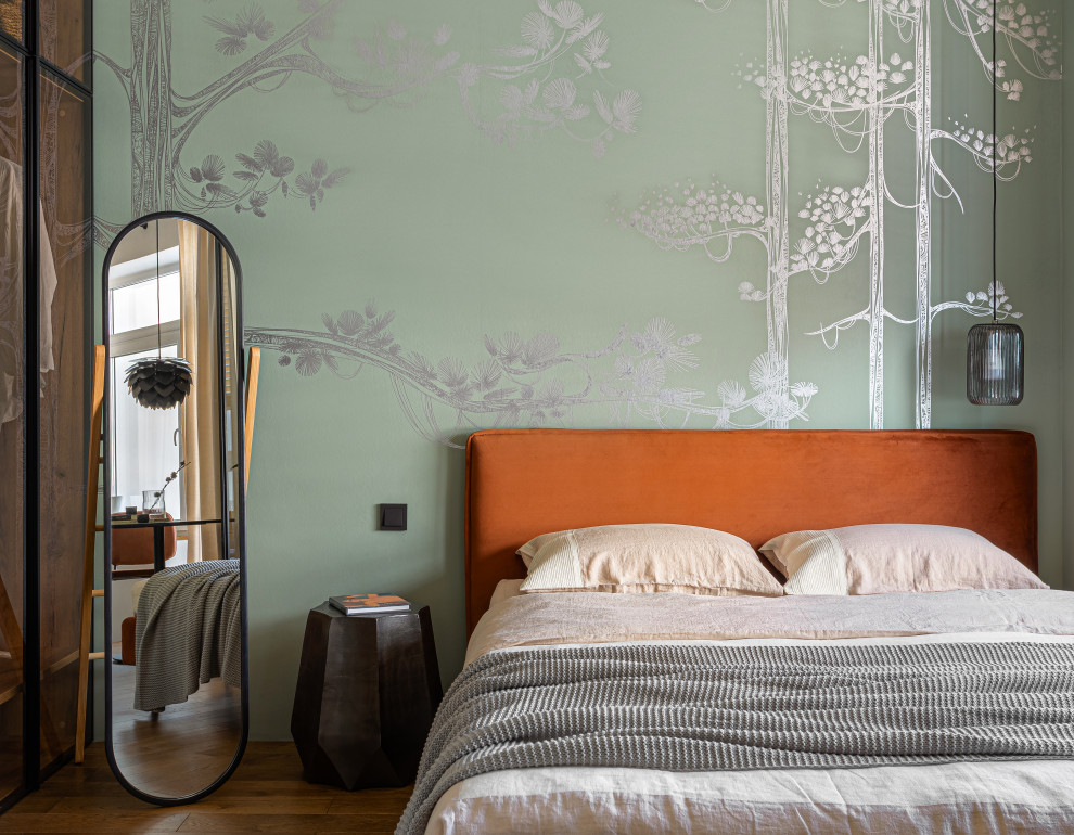 Immagine di una piccola camera matrimoniale minimal con pareti verdi, parquet scuro e pavimento marrone