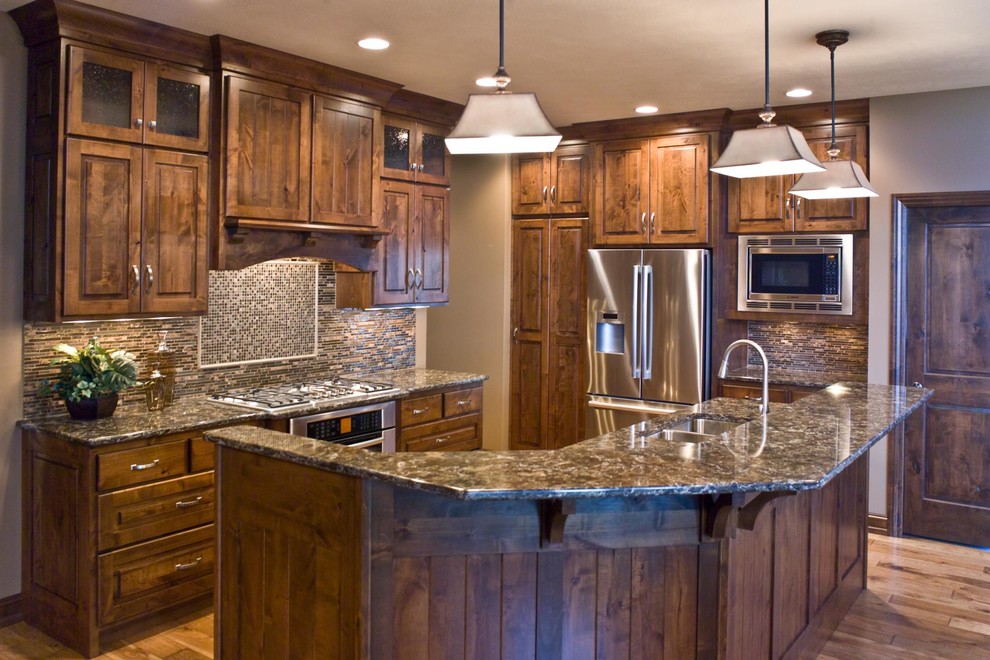 Elegant eat-in kitchen photo with dark wood cabinets, multicolored backsplash, stainless steel appliances and an island