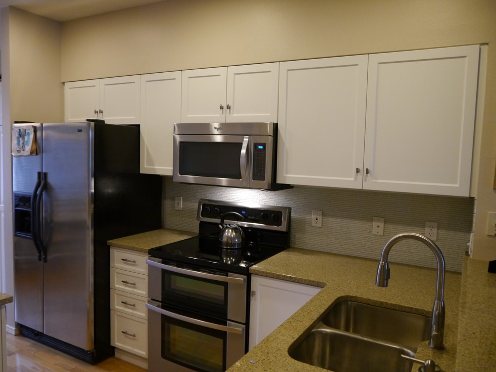 Eat-in kitchen - transitional eat-in kitchen idea in Seattle with an undermount sink, shaker cabinets, white cabinets, granite countertops, glass tile backsplash, stainless steel appliances and an island