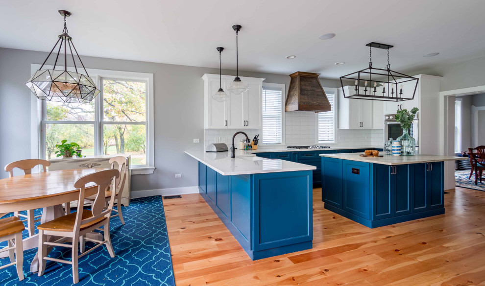 Large country l-shaped light wood floor, brown floor and wallpaper ceiling eat-in kitchen photo in Chicago with a farmhouse sink, shaker cabinets, turquoise cabinets, marble countertops, white backsplash, porcelain backsplash, stainless steel appliances, an island and multicolored countertops