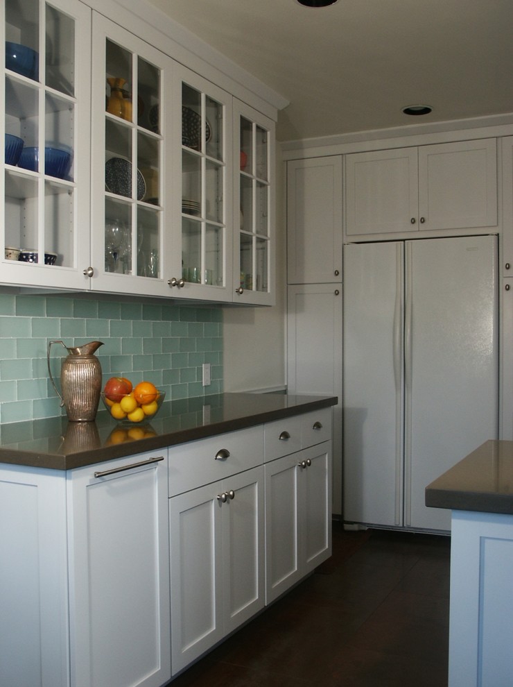 This is an example of a mid-sized eclectic u-shaped eat-in kitchen in Los Angeles with an undermount sink, shaker cabinets, white cabinets, quartz benchtops, green splashback, glass tile splashback, white appliances, porcelain floors and no island.