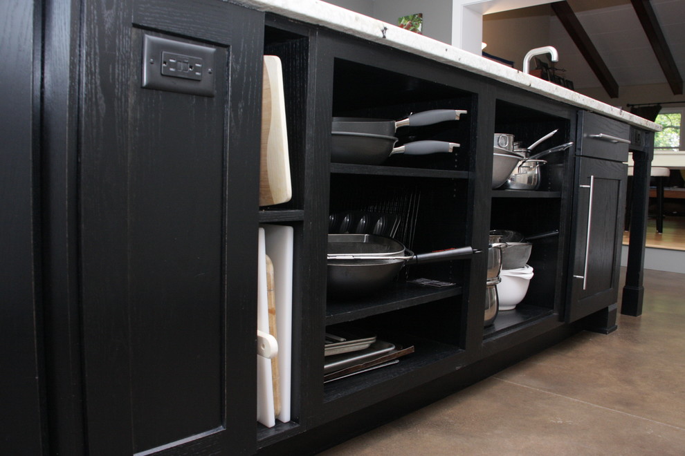 Inspiration for a large contemporary storage and wardrobe in Cincinnati with black cabinets and concrete floors.