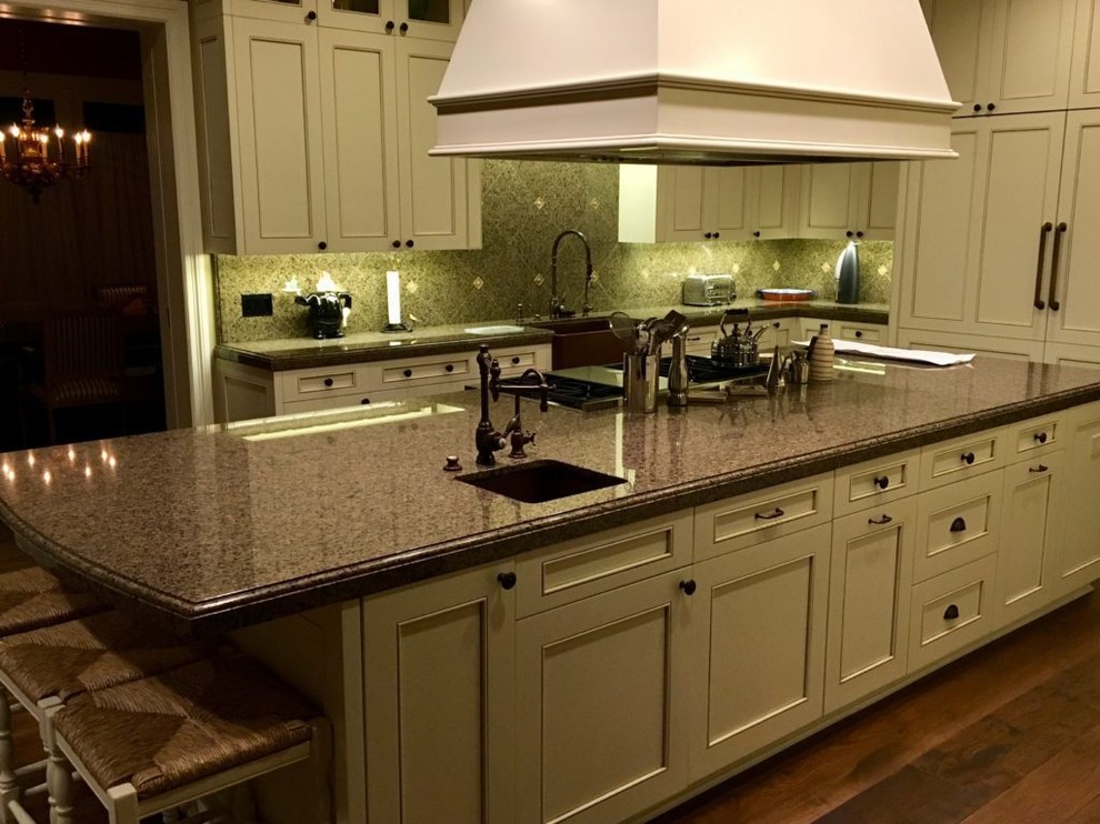 Inspiration for a large transitional kitchen remodel with an undermount sink, white cabinets, granite countertops, beige backsplash, black appliances and an island